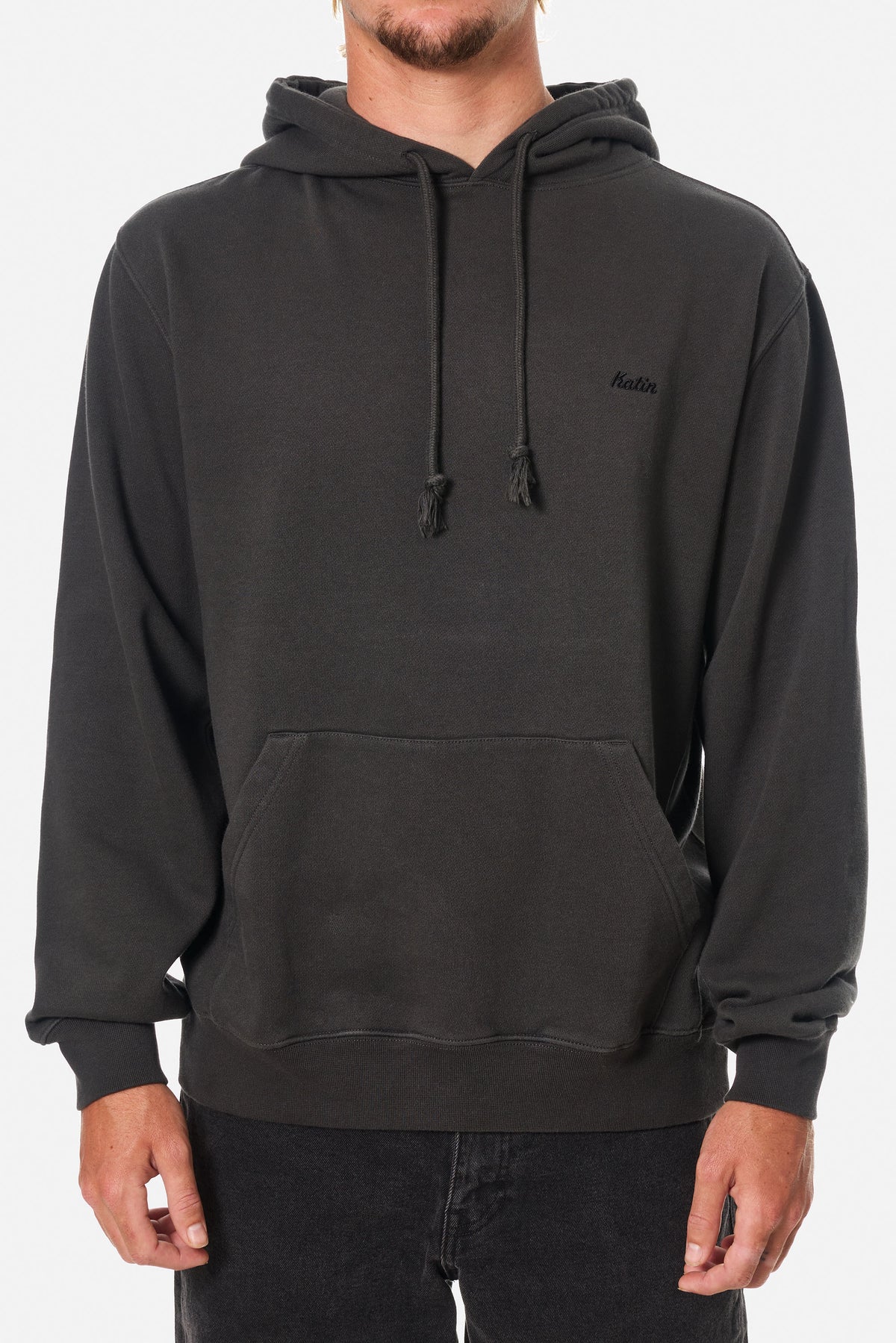 Person wearing a black wash hoodie sweatshirt with an embroidered Katin logo on a white background