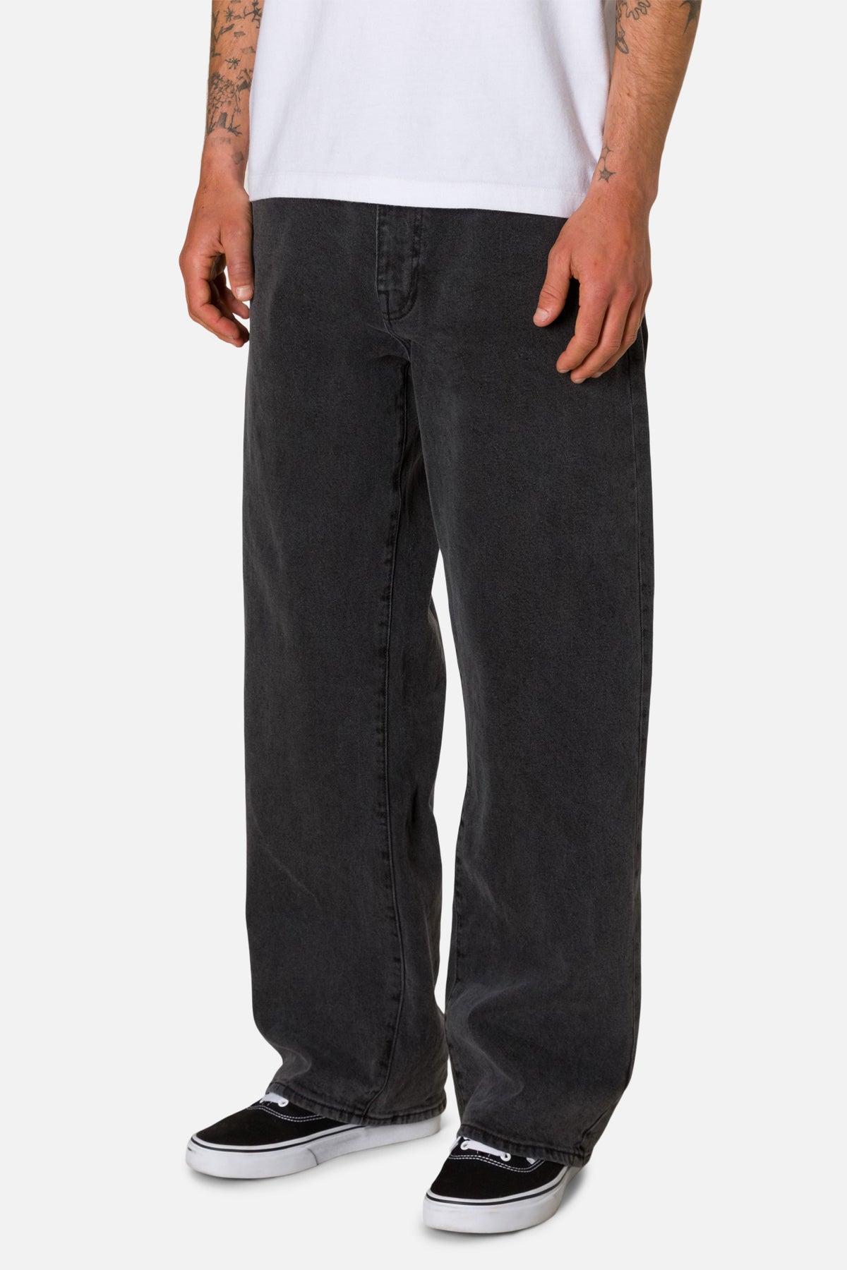 Black washed jeans worn by a person on a white background