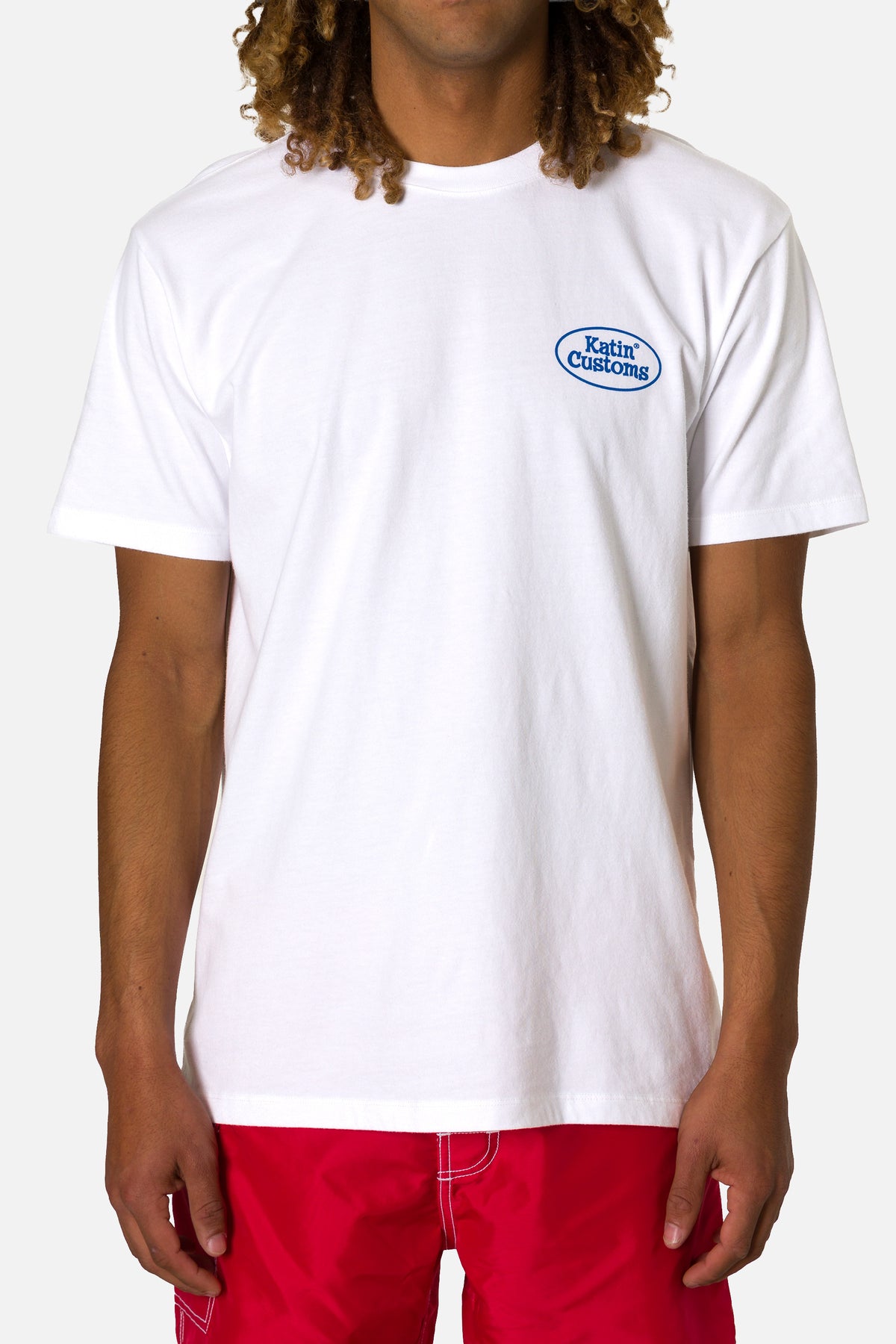 Person wearing a white t-shirt with a logo on a plain background