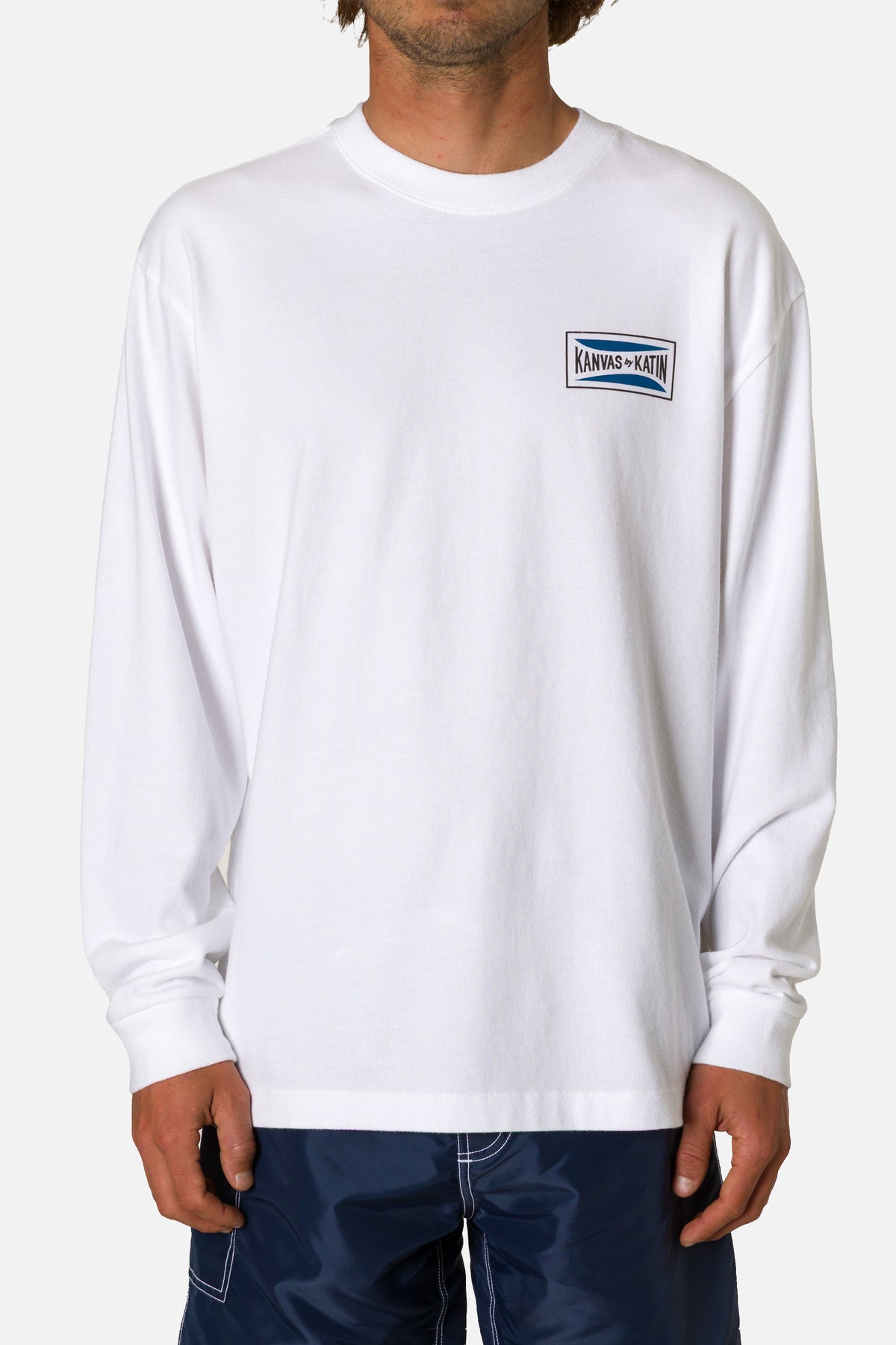 Person wearing a white long-sleeve shirt with a logo on a white background