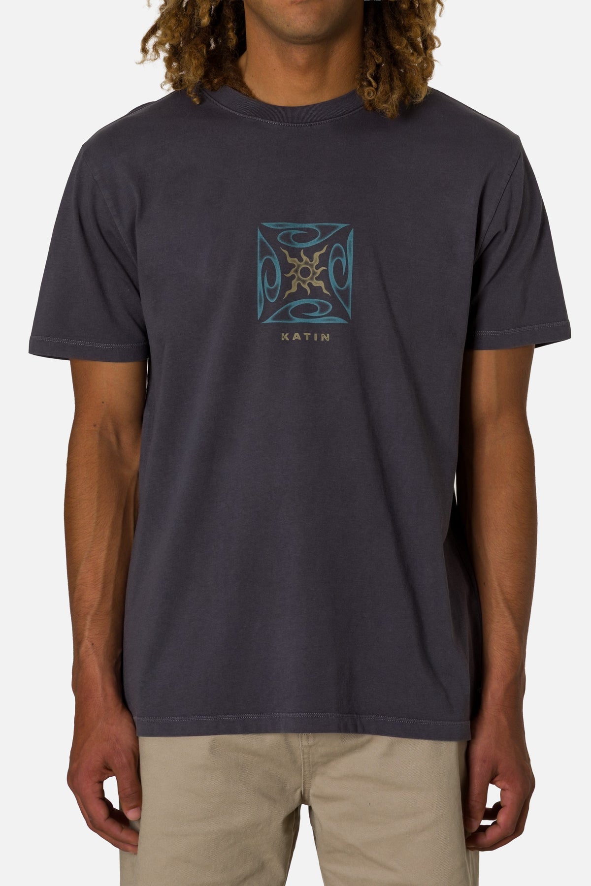 Person wearing a dark gray t-shirt with a logo on a white background