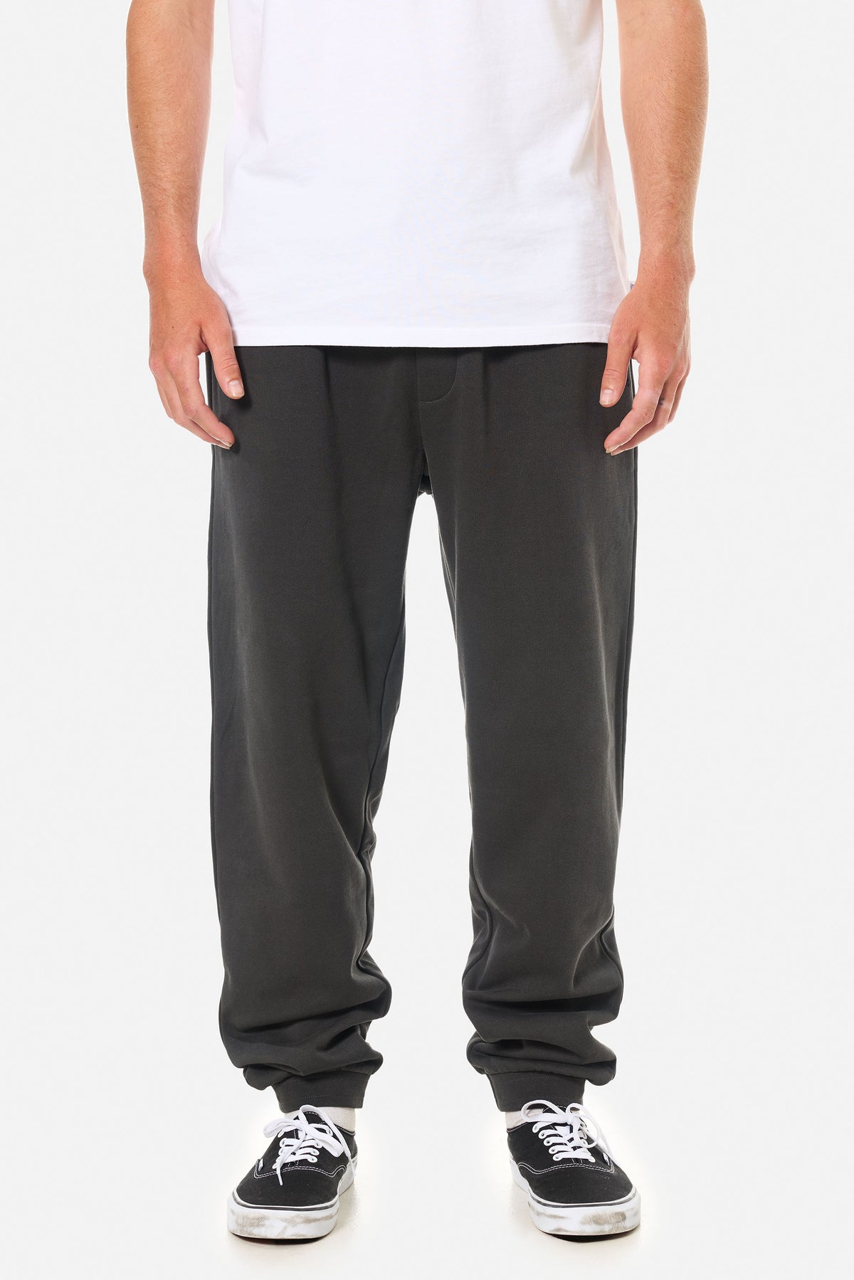Person wearing black wash lounge pants on a white background