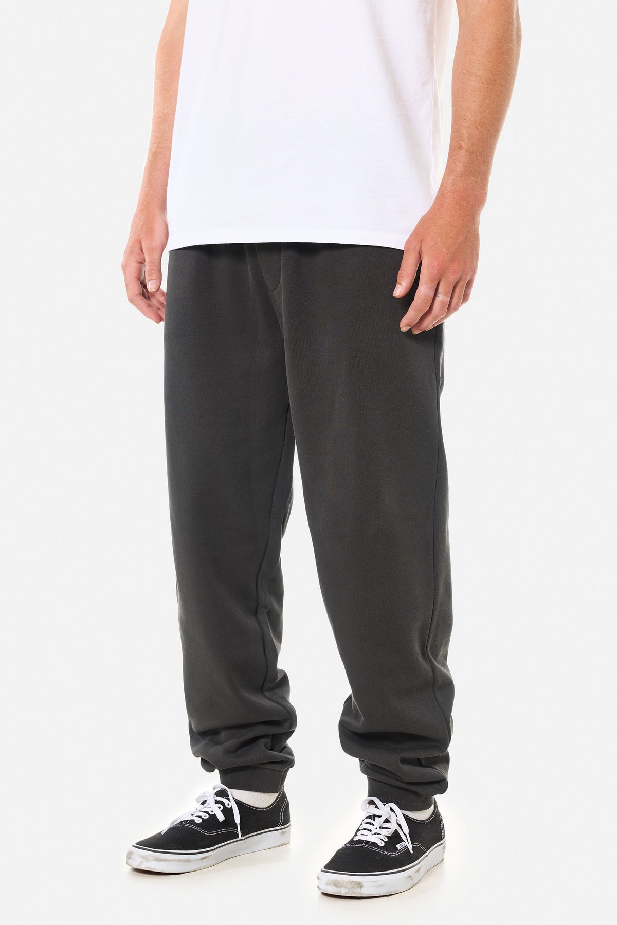 Person wearing black wash lounge pants on a white background
