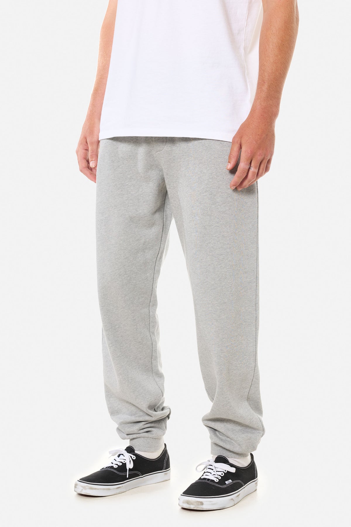 Person wearing light grey lounge pants on a white background