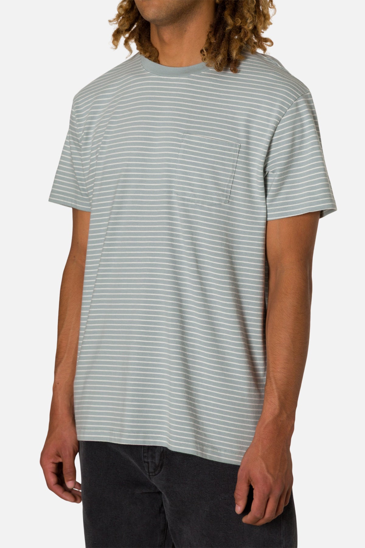 Man wearing a light gray and white striped t-shirt on a plain background