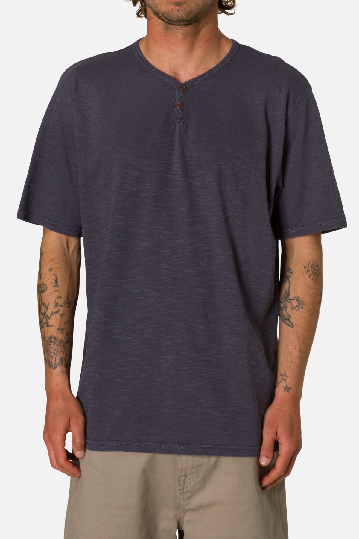 Man wearing a navy henley shirt on a white background