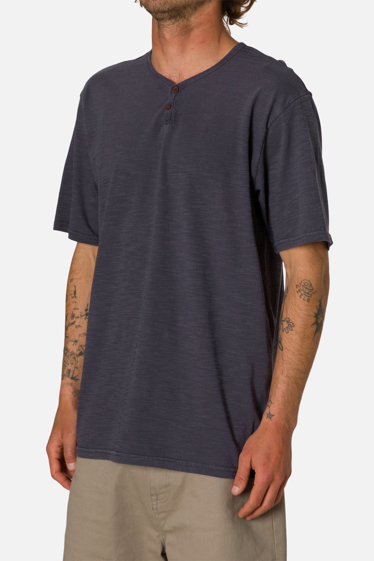 Man wearing a navy henley shirt on a white background