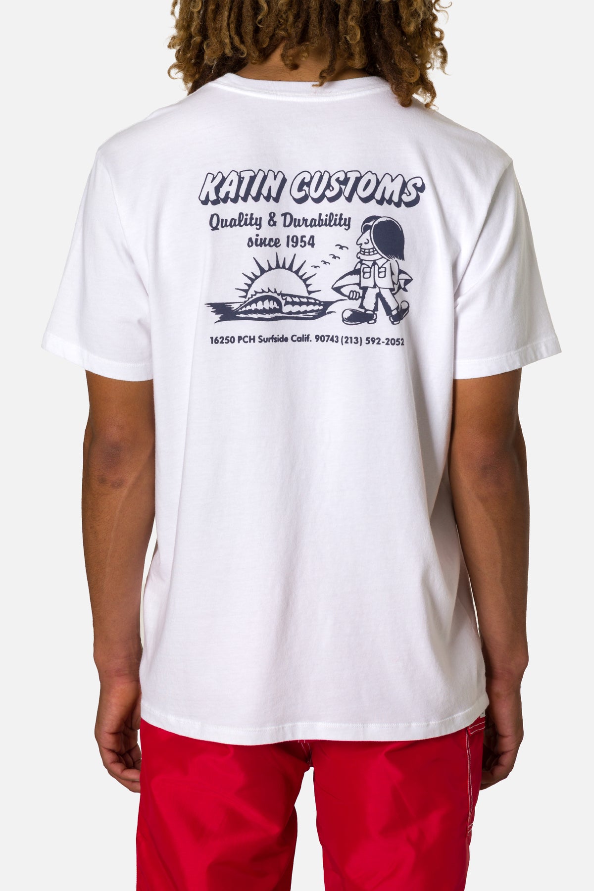 Person wearing a white t-shirt with a graphic design and text on the back.