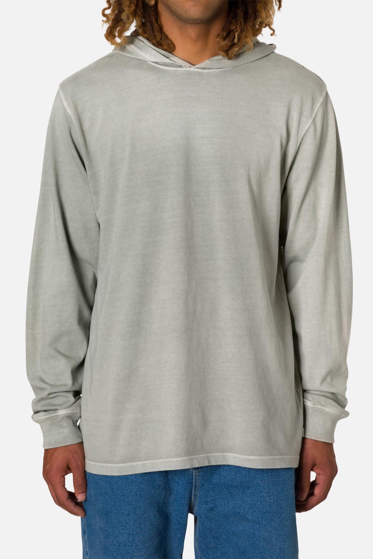 Person wearing a off white hoodie and blue jeans on a white background