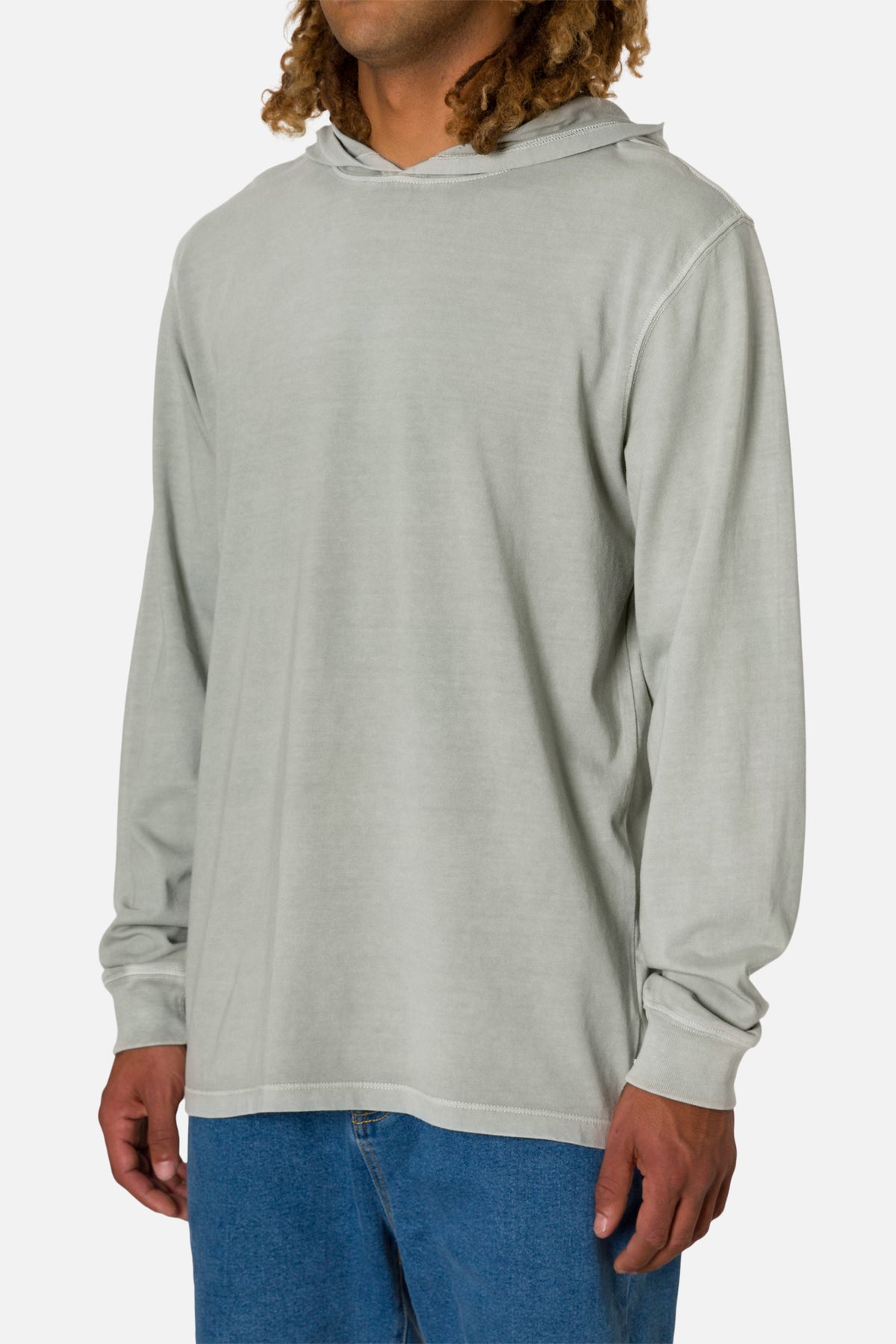 Person wearing a off white hoodie and blue jeans on a white 