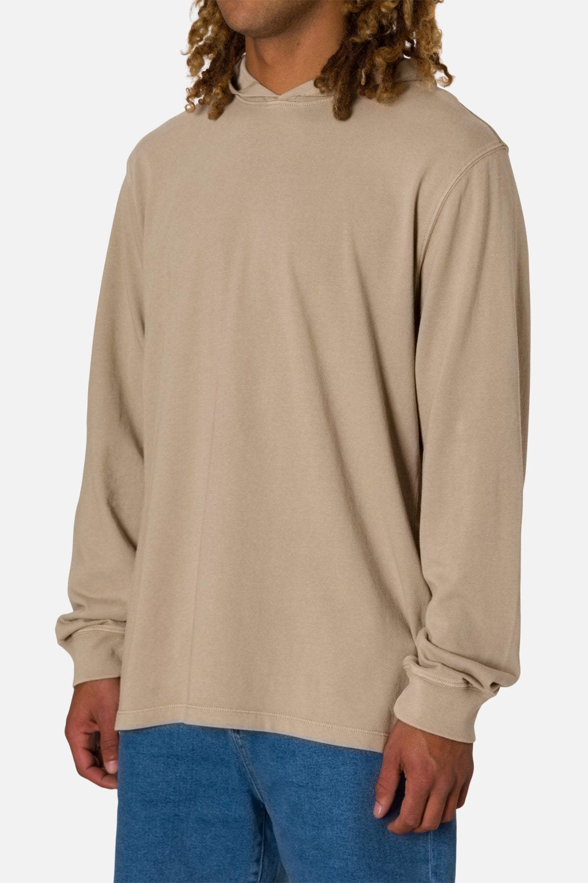 Person wearing a beige long-sleeve hoodie on a white background