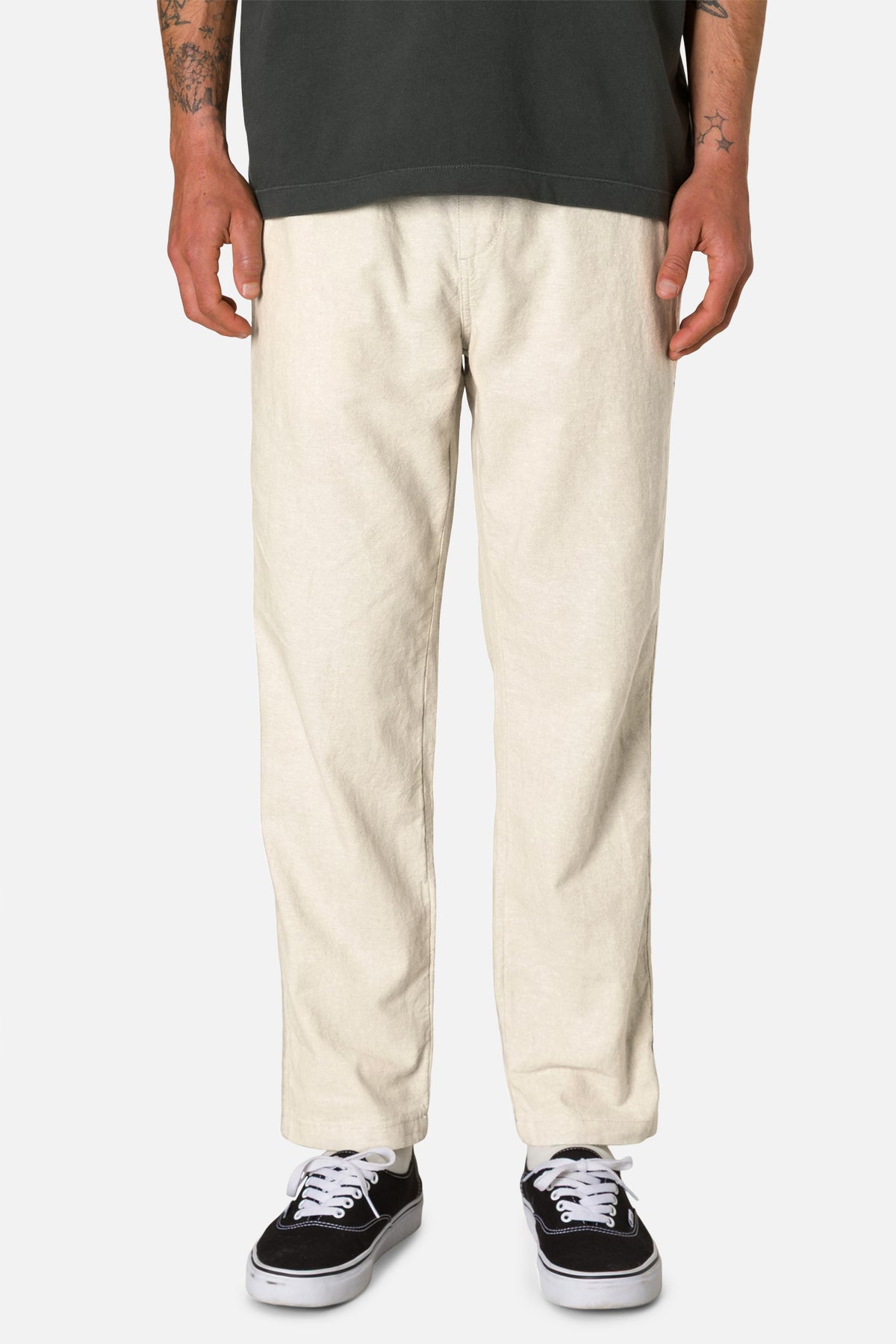 Person wearing white pants and black shoes on a white background