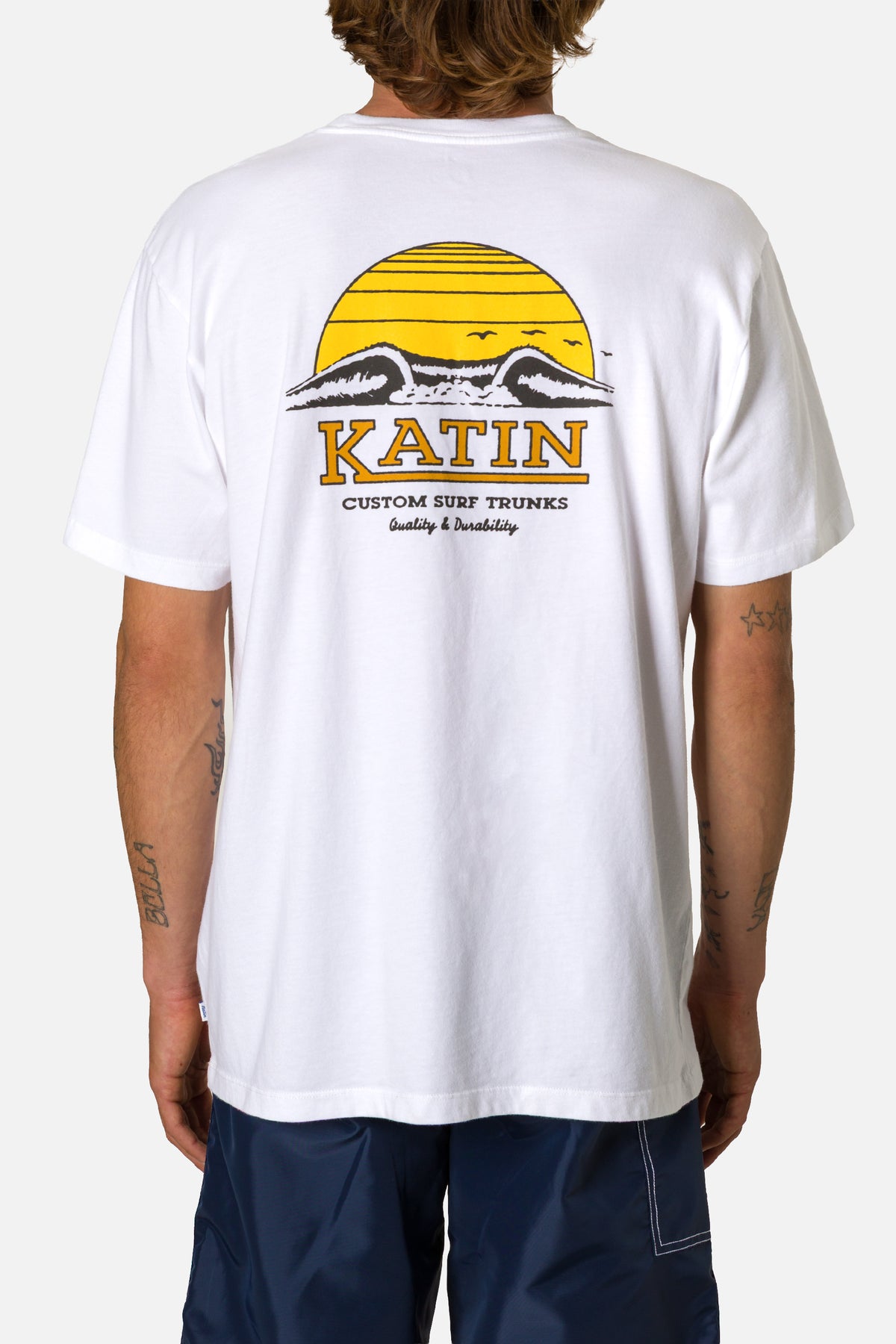 Person wearing a white t-shirt with a Katin logo and design on the back.