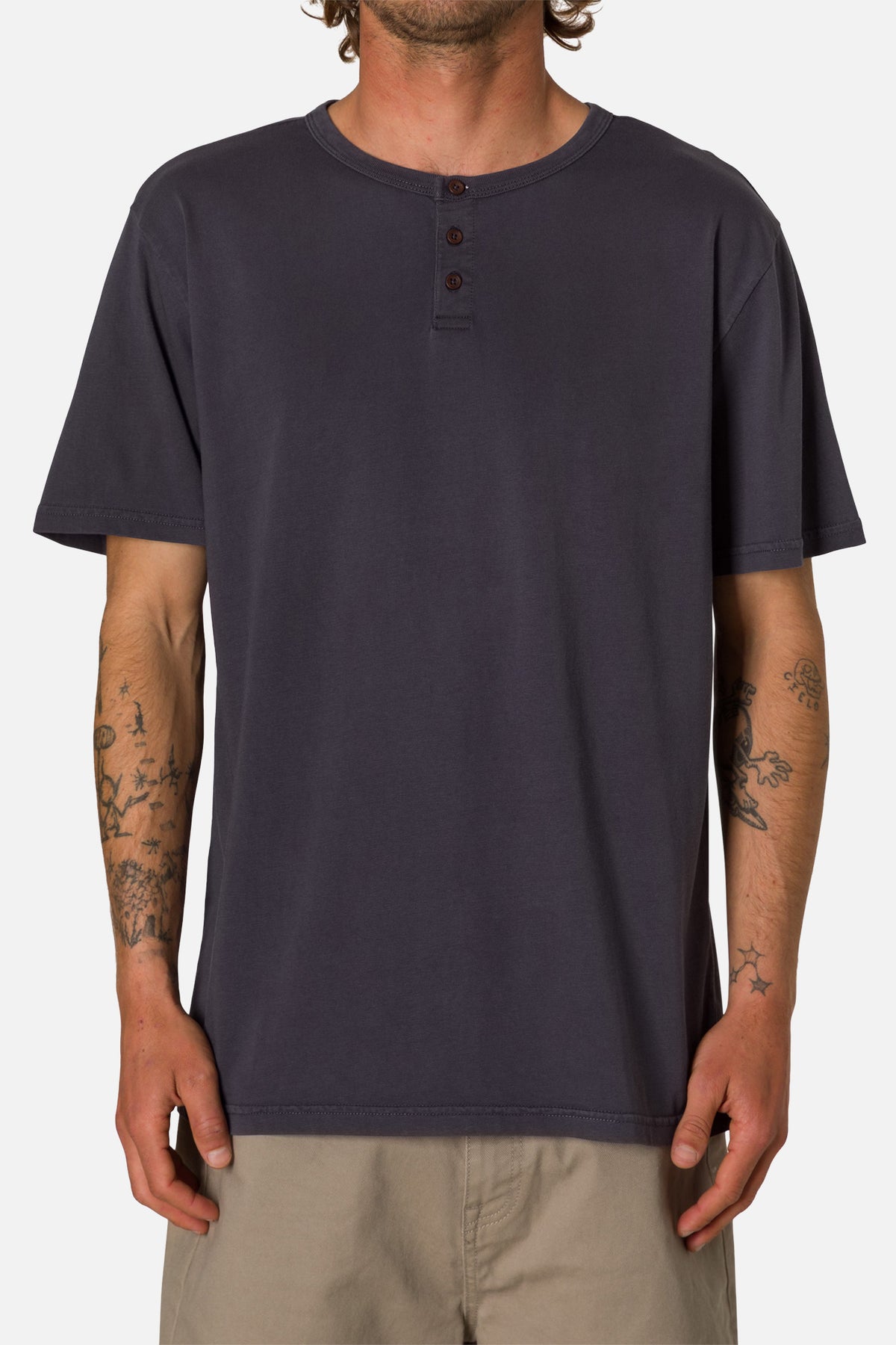 Person wearing a navy henley shirt on a white background