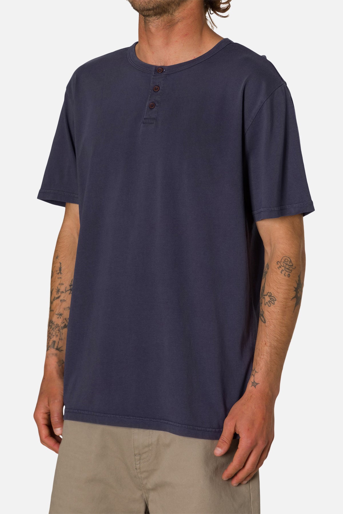 Man wearing a navy blue henley shirt on a white background
