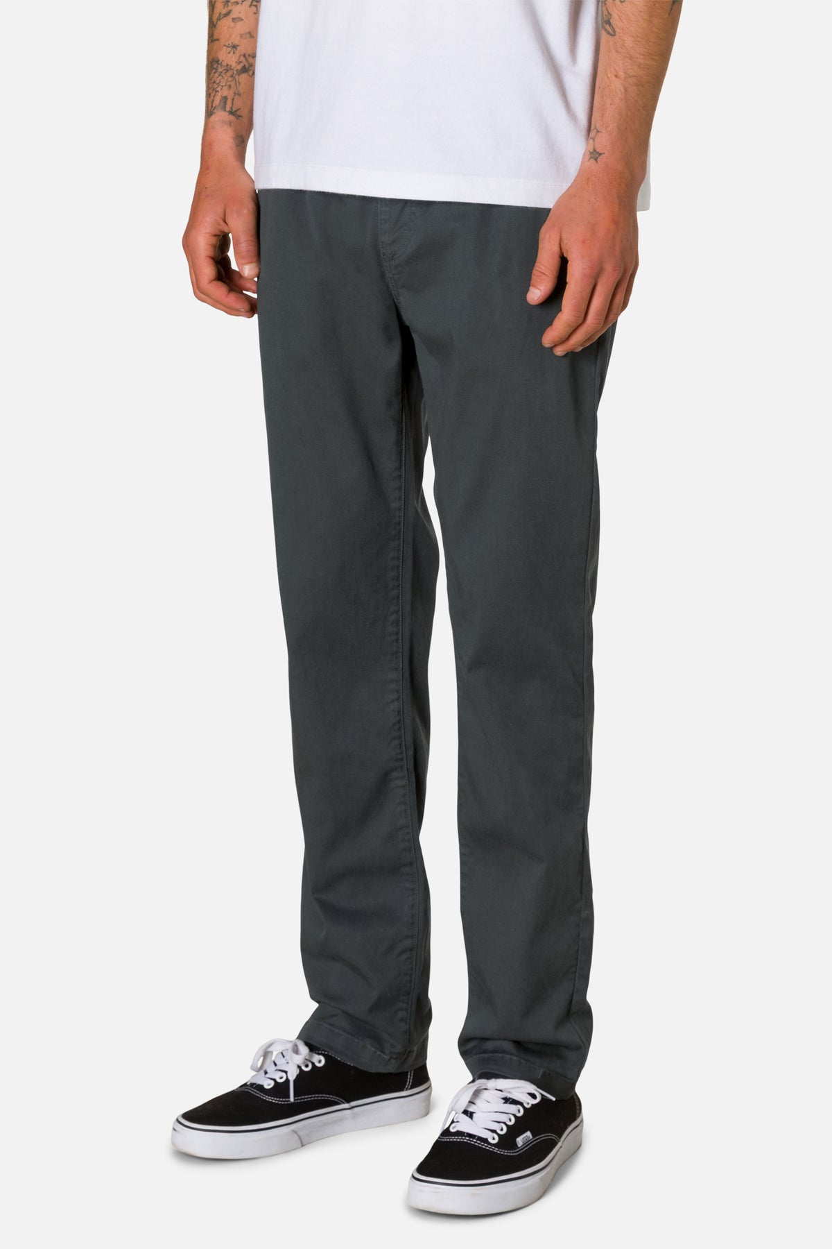 Person wearing gray pants and black sneakers on a white background