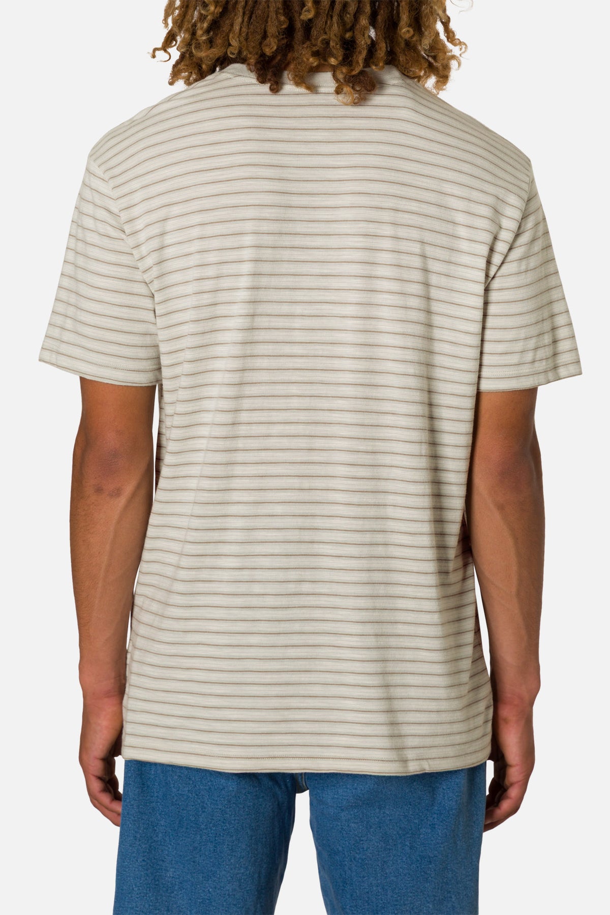 Person wearing a beige striped t-shirt and blue jeans on a white background