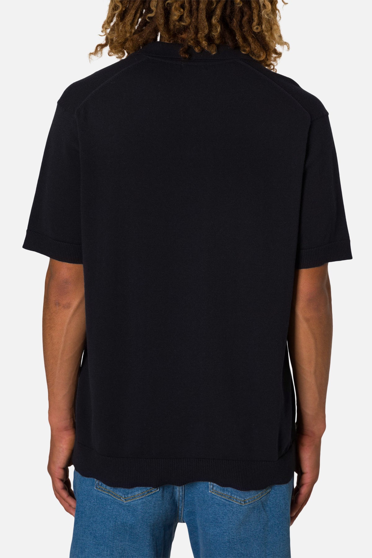 Person wearing a black t-shirt and blue jeans on a white background