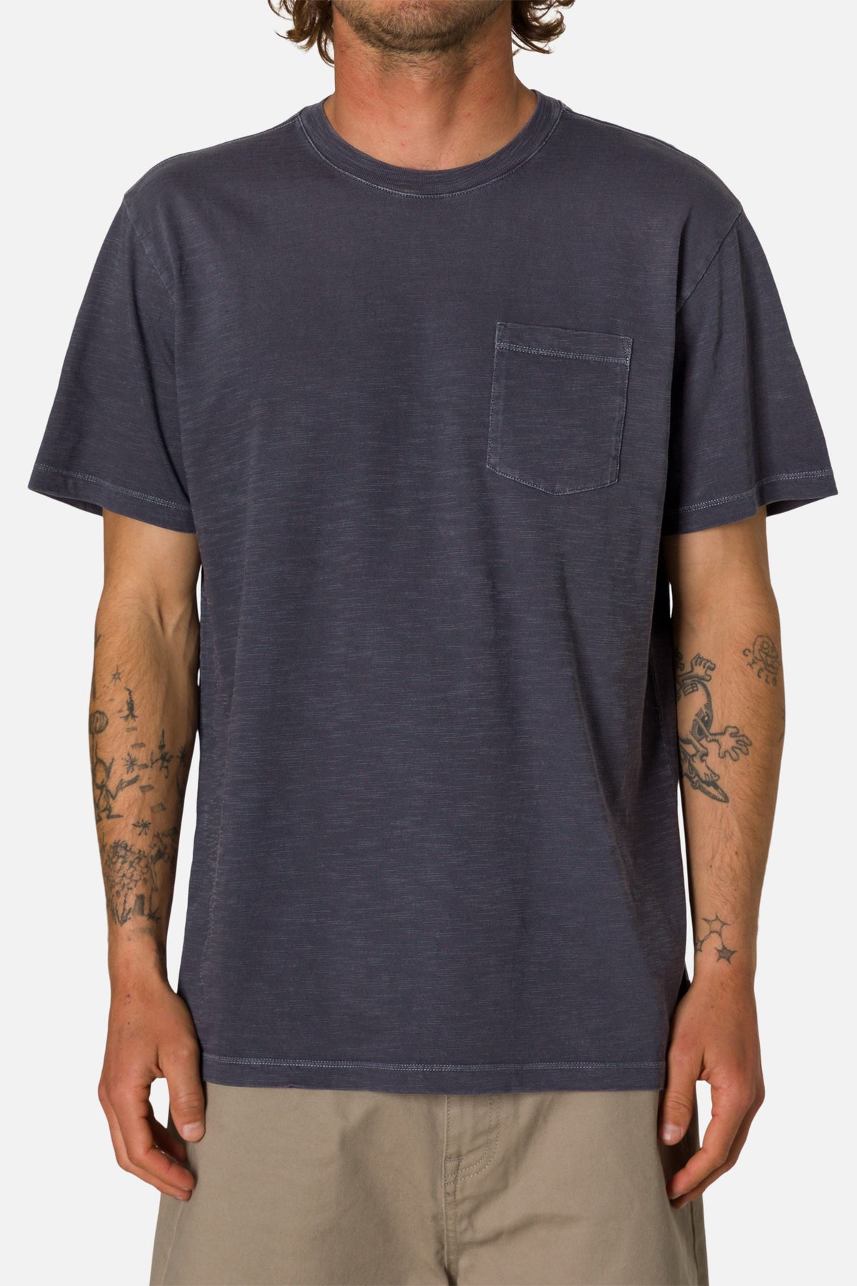 Man wearing a dark blue t-shirt with a pocket on a white background