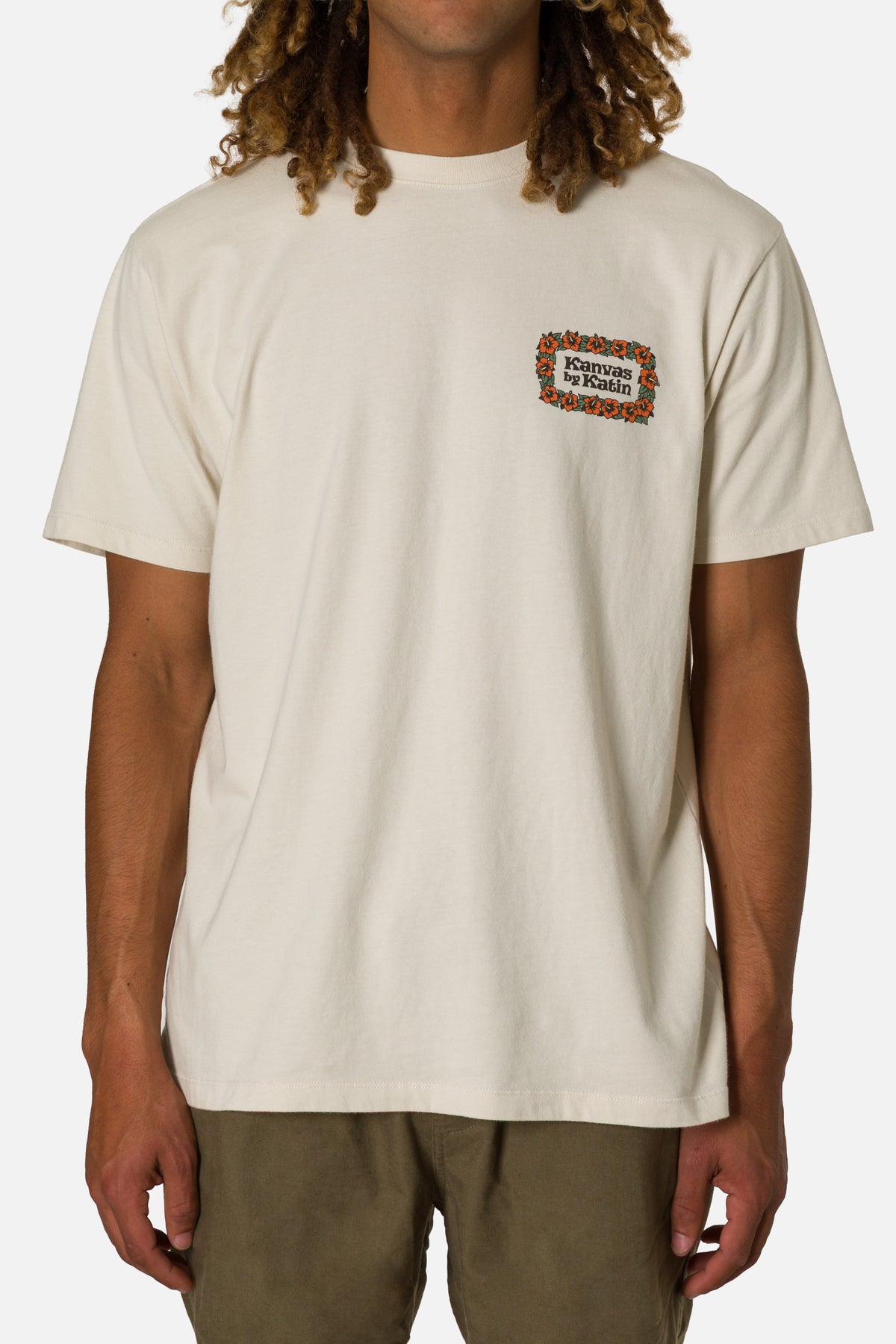 Person wearing a beige t-shirt with a small graphic on a white background