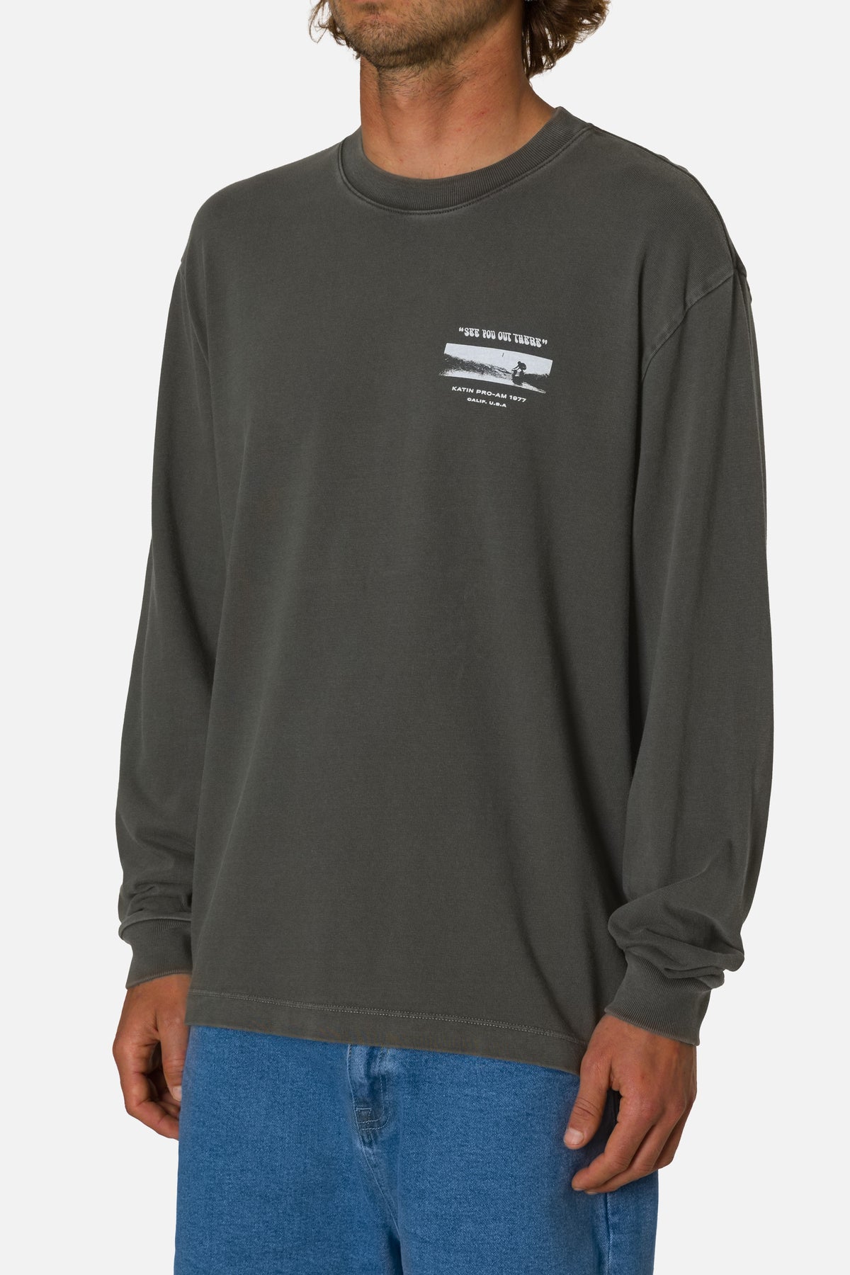 Person wearing a dark gray long-sleeve shirt with a graphic design on a white background